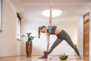 Frau macht Yoga in hellem Raum.
