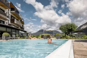 Mann schwimmt im Pool bei sonnigem Wetter