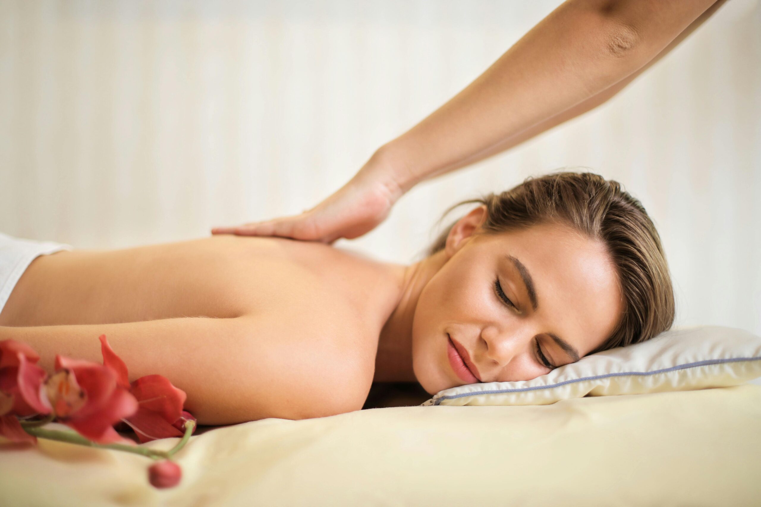 Frau genießt entspannende Rückenmassage mit Blume